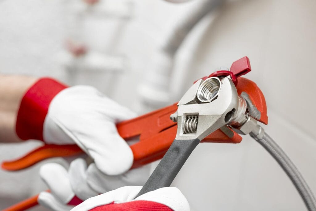 Plumber holding pipe wrenches for an emergency repair in Hemet