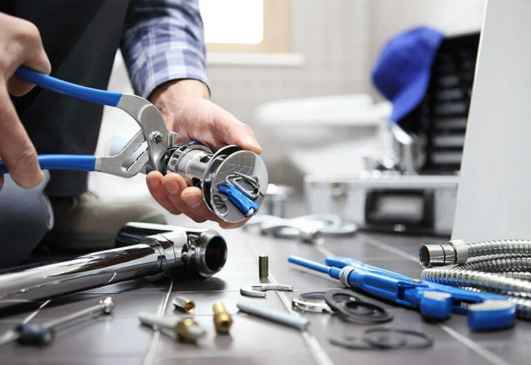 Technician repairing a plumbing fixture with professional tools in Hemet