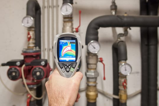 Plumber using a thermal imaging camera to inspect pipes in Hemet