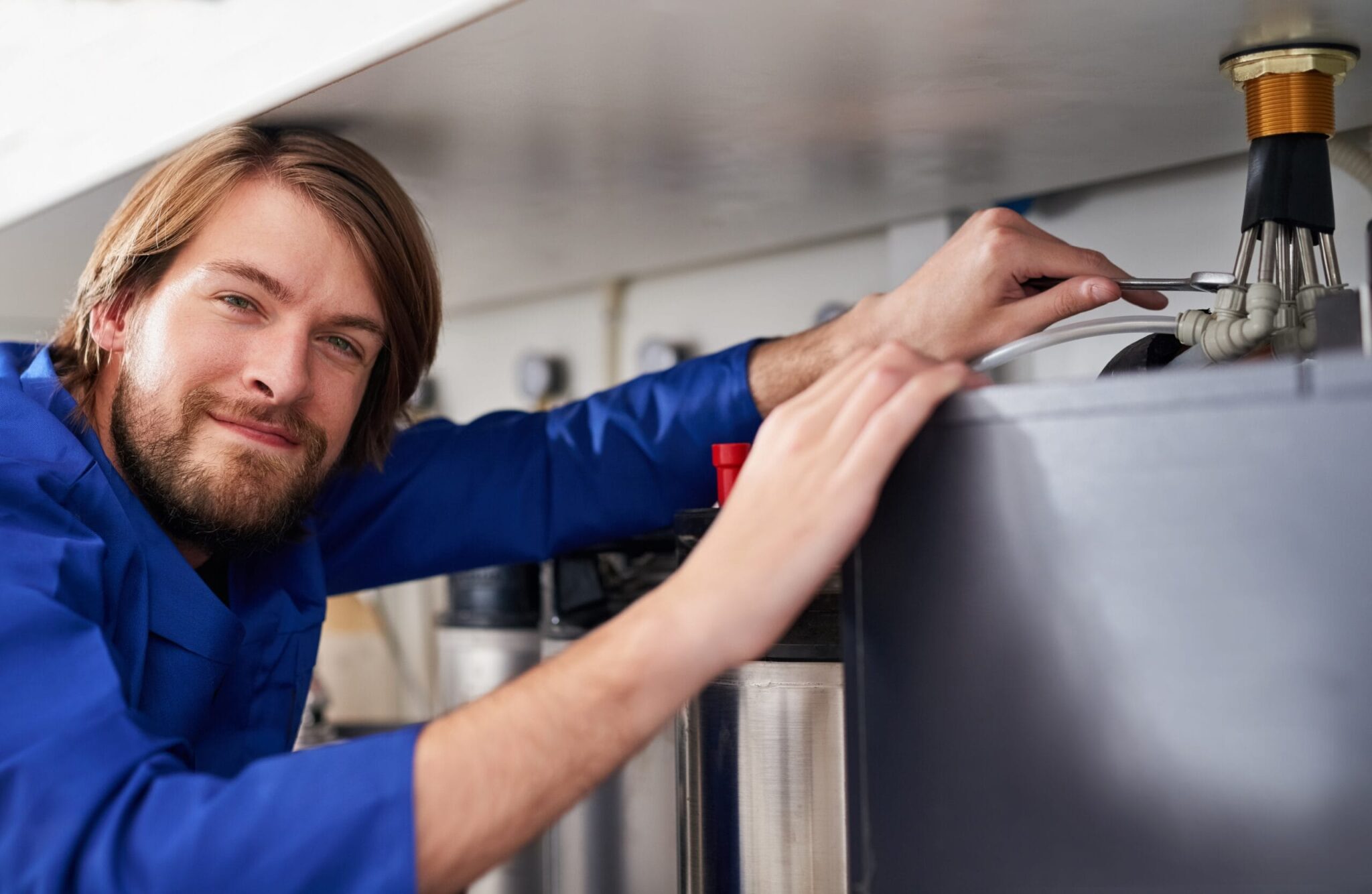 Technician servicing a residential water heater tank in Hemet