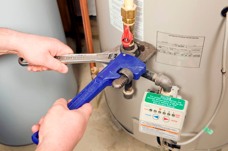 Plumber repairing a water heater valve in Hemet